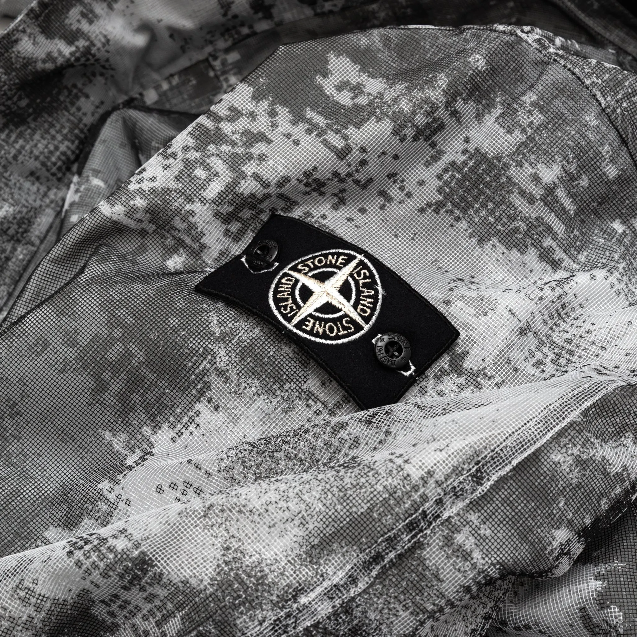 DISSOLVING GRID CAMO MESH ON REFLECTIVE ECONYL® REGENERATED JACKET