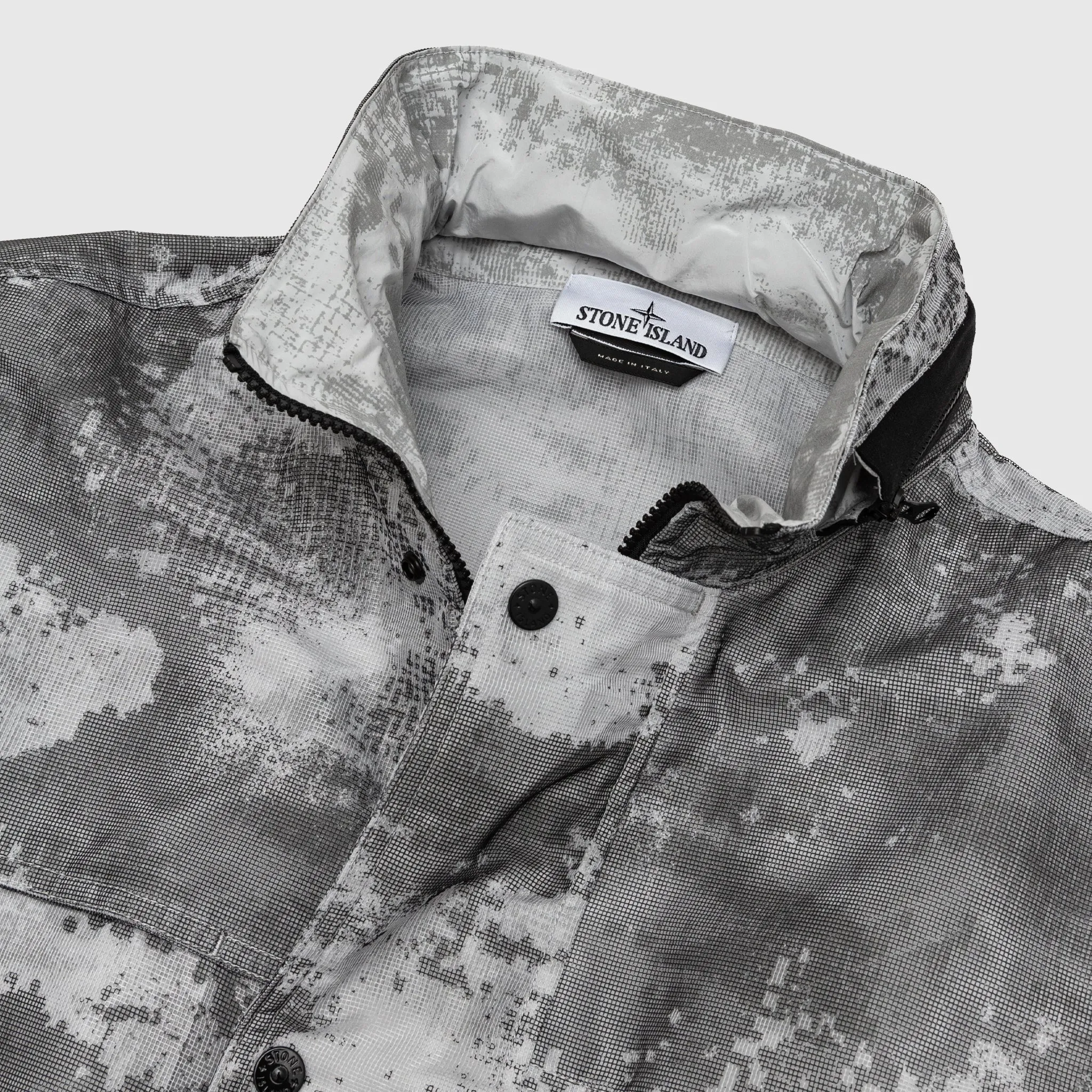 DISSOLVING GRID CAMO MESH ON REFLECTIVE ECONYL® REGENERATED JACKET