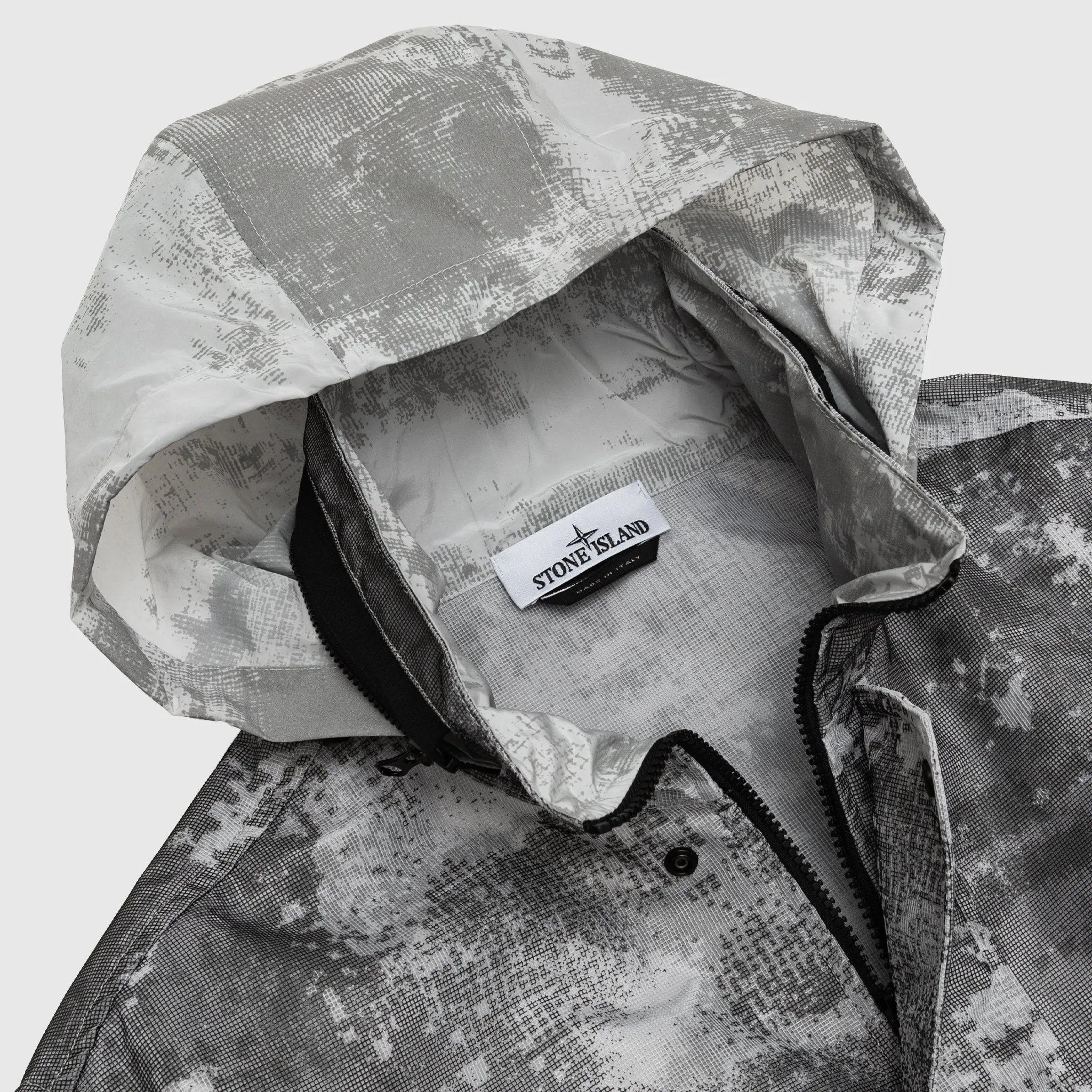 DISSOLVING GRID CAMO MESH ON REFLECTIVE ECONYL® REGENERATED JACKET